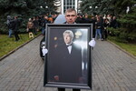 Портрет телеведущего Юрия Николаева во время выноса гроба на церемонии прощания на Троекуровском кладбище, 8 ноября 2025 года