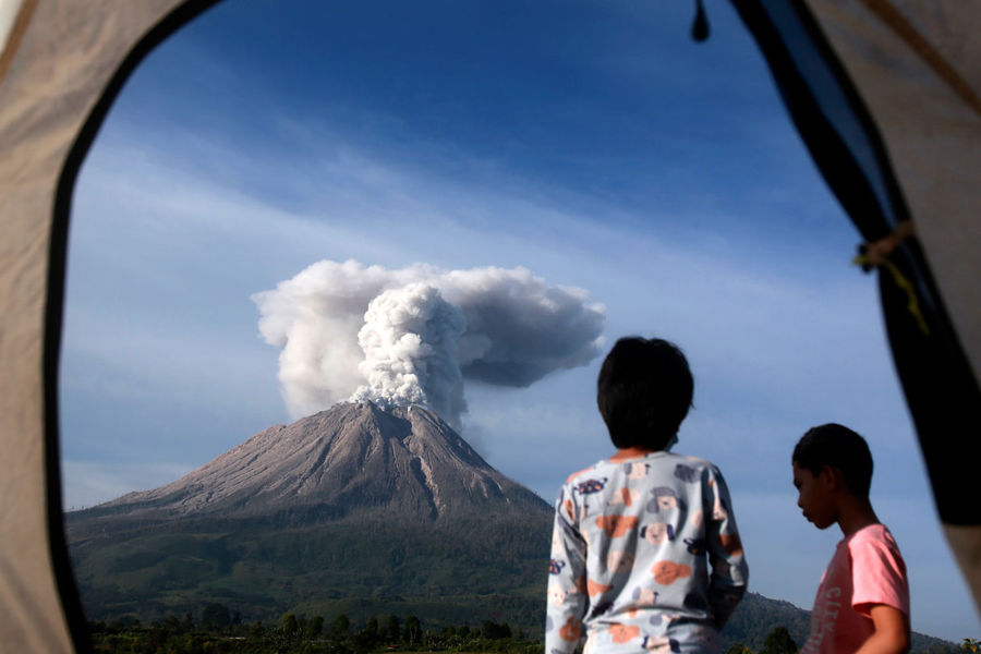 Туристы наблюдают из&nbsp;палатки, как извергается вулкан Синабунг в&nbsp;провинции Северная Суматра, Индонезия, 11 марта 2021 года