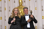 Певица Адель и продюсер, музыкант Пол Эпуорт позируют с Оскаром за песню «Skyfall», главного саундтрека к фильму о Бонде, 2013 год 