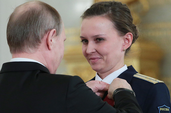 Президент РФ Владимир Путин и инженер отделения сигнализации 1073-го Центра управления ВКС старший лейтенант Елена Веселова, награжденная медалью ордена «За заслуги перед Отечеством» II степени, в Кремле на церемонии вручения государственных наград военнослужащим и специалистам военно-промышленного комплекса, отличившимся в ходе выполнения специальных задач в Сирии