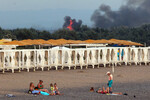 Отдыхающие на пляже во время взрывов в районе поселка Новофедоровка в Крыму, 9 августа 2022 года
