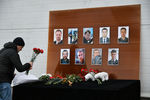 Мужчина возлагает цветы у телевизионного центра «Останкино» к фотографиям журналистов, погибших при крушении самолета Минобороны РФ Ту-154 у побережья Черного моря в Сочи
