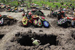 Солдат копает могилы для жителей Крымска, погибших во время наводнения в городе