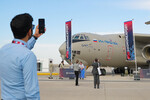Посетитель фотографирует тяжелый транспортный Ил-76МД-90А(Э) на Международном авиационно-космическом салоне Dubai Airshow-2023 в Дубае