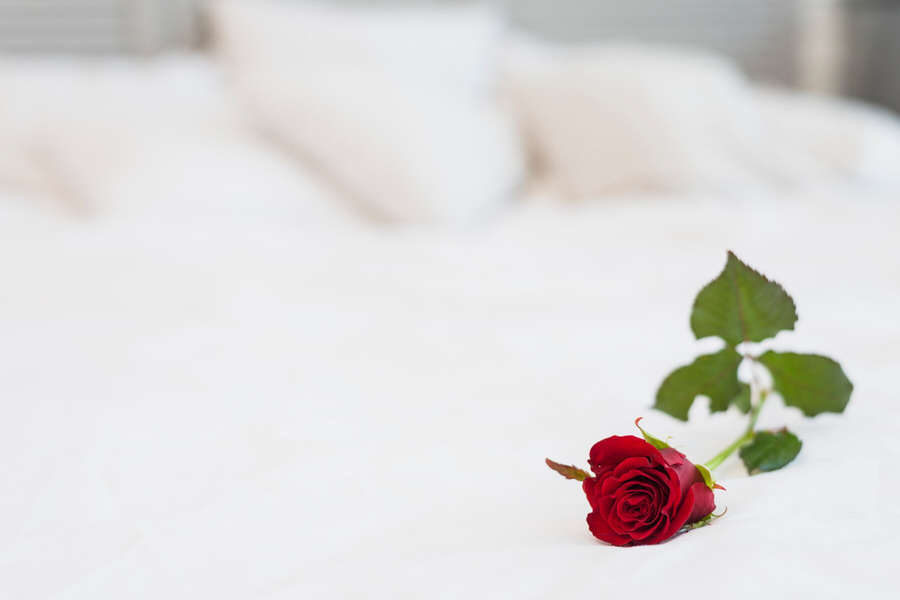 vinous-rose-bed-with-white-linen_23-2148