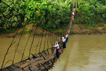 19 января. Школьники преодолевают подвесной мост, разрушенный вышедшей из берегов рекой Cиберанг в Индонезии.