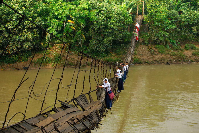 19&nbsp;января. Школьники преодолевают подвесной мост, разрушенный вышедшей из&nbsp;берегов рекой Cиберанг в&nbsp;Индонезии.