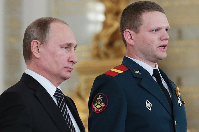 Владимир Путин и командир отделения реактивной артиллерийской батареи 810-й отдельной бригады морской пехоты Черноморского флота младший сержант Олег Баранов (слева направо), награжденный знаком отличия «Георгиевский Крест» IV степени, в Кремле на церемонии вручения государственных наград военнослужащим и специалистам военно-промышленного комплекса, отличившимся в ходе выполнения специальных задач в Сирии