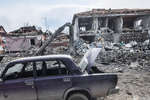 Разрушенные дома и разбитая машина в Мариуполе, март 2022 года