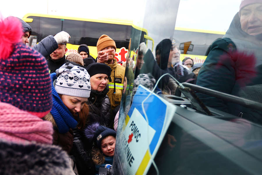 Беженцы из Украины возле временного размещения в Перемышле садятся в автобус до Варшавы, 2022 год