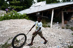 Мальчик играет на фоне разрушенного землетрясением здания, Гаити, 17 августа 2021 года