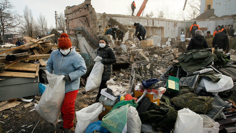 Люди собирают свои вещи в развалинах здания после обстрелов Донецка, февраль 2017 года