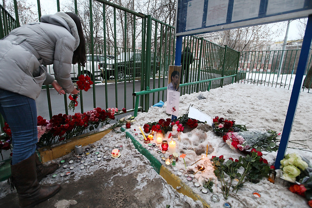 Девушка возлагает цветы у московской школы №263 в Отрадном