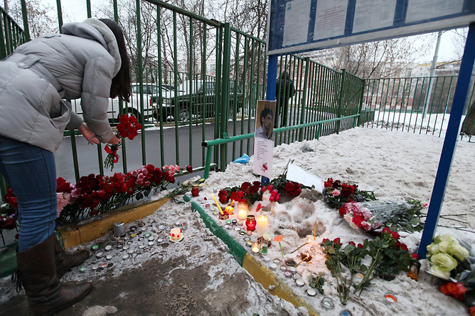Девушка возлагает цветы у московской школы №263 в Отрадном