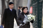 Женщина несет цветы к посольству Северной Кореи в Пекине