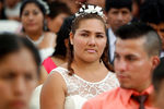 Одна из невест на массовой свадьбе в Перу. В торжественной церемонии, состоявшейся в Лиме, приняло участие 67 пар