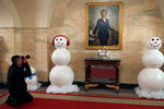 Снеговики рядом с портретом бывшей первой леди США Хиллари Клинтон