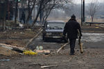 Житель города Дебальцево несет ветви деревьев для разжигания костра, на котором жильцы пострадавших в результате боевых действий жилых домов готовят еду