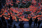 Люди приносят цветы и свечи к зданию философского факультета Карлова университета в Праге в память о погибших в результате массовой стрельбы, Чехия, 22 декабря 2023 года