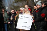 Люди у стихийного мемориала возле памятника героям обороны Красного Царицына в Волгограде, 23 марта 2024 года