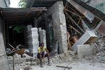 Мужчина перед разрушенным похоронным бюро в Ле-Кее, Гаити, 16 августа 2021 года