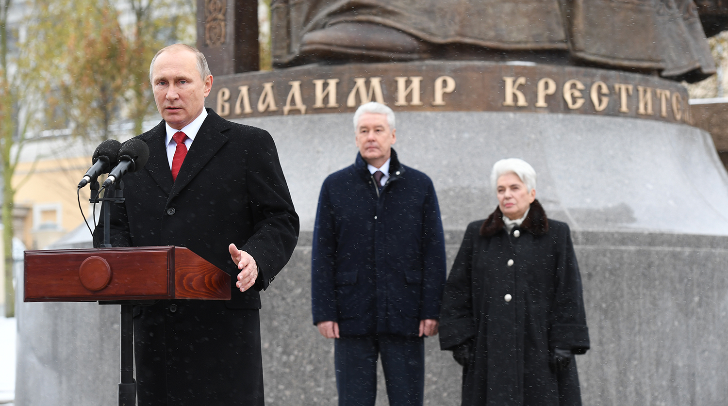 Президент России Владимир Путин, мэр Москвы Сергей Собянин и вдова Александра Солженицына Наталия во время церемонии открытия памятника князю Владимиру около Кремля, 2016 год