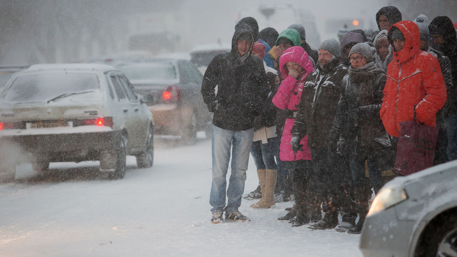 Жители города на&nbsp;остановке общественного транспорта во время сильного снегопада