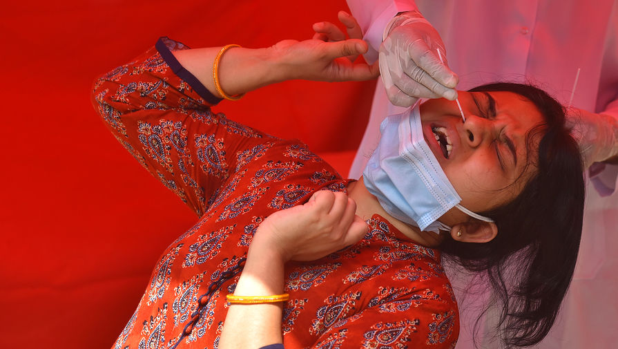 Девушка сдает тест ПЦР на коронавирусную инфекцию в пункте тестирования в Дели