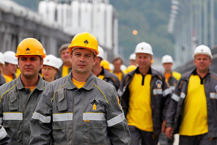 Рабочие идут на смену на нефтеперерабатывающий завод компании «Роснефть»