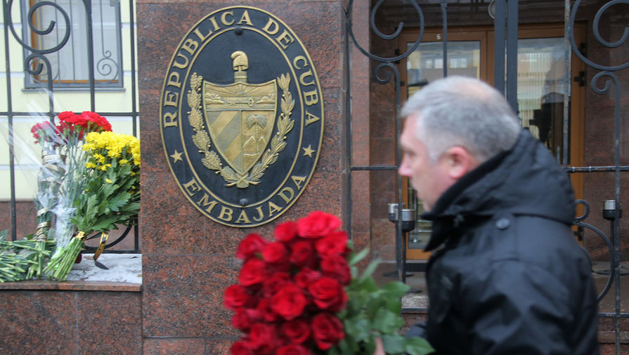 Мужчина несет цветы к&nbsp;посольству Кубы в&nbsp;Москве