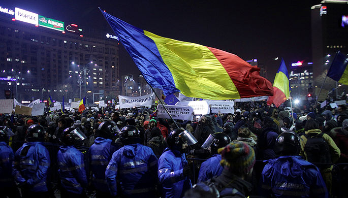 Протестующие с румынским флагом во время демонстрации в Бухаресте, 1 февраля 2017 года