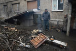 Жители города Дебальцево готовят еду на костре у подъезда жилого многоквартирного дома, пострадавшего в результате боевых действий
