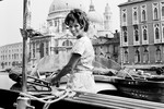 «Королева» Венецианского кинофестиваля актриса Клаудия Кардинале стоит за штурвалом моторной лодки на Гранд-канале в Венеции, 30 октября 1967 года