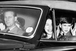 Герцог Эдинбургский Филипп за рулем, королева Великобритании Елизавета II, и их дети принц Чарльз и принцесса Анна во время поездки из Букингемского дворца в Виндзорский замок на Пасху, 1956 год