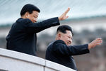 Лидер КНДР Ким Чен Ын (справа) и член постоянного комитета политбюро ЦК КПК Лю Юньшань приветствуют участников парада в честь 70-летия Трудовой партии Кореи