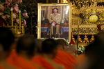 Буддистские монахи молятся рядом с изображением нового короля в Бангкоке
