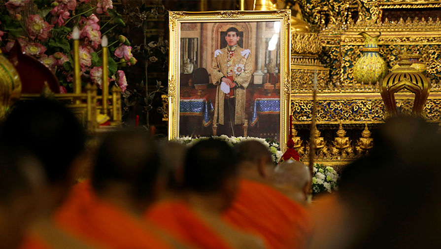 Буддистские монахи молятся рядом с&nbsp;изображением нового короля в&nbsp;Бангкоке