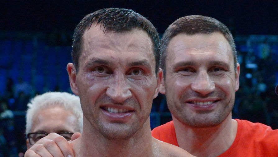 Владимир Кличко радуется победе в бою за титул чемпиона мира по версиям WBA, IBF, WBO и IBO, справа — его брат Виталий Кличко