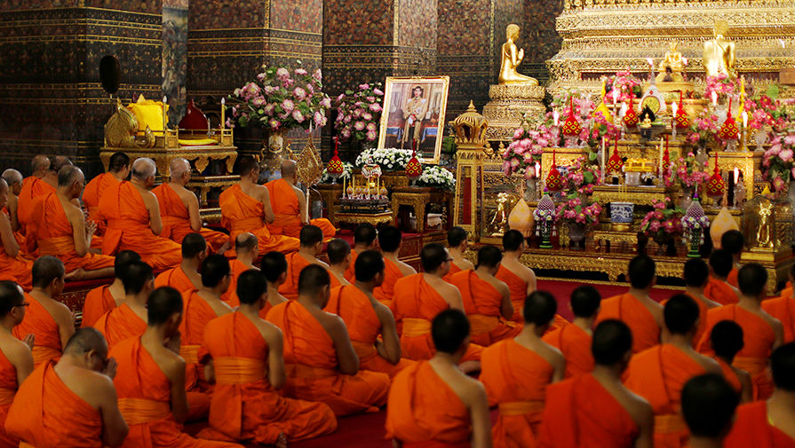Буддистские монахи молятся рядом с&nbsp;изображением нового короля в&nbsp;Бангкоке