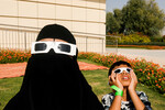 Люди наблюдают за частичным солнечным затмением в Дубае, ОАЭ, 25 ноября 2022 года