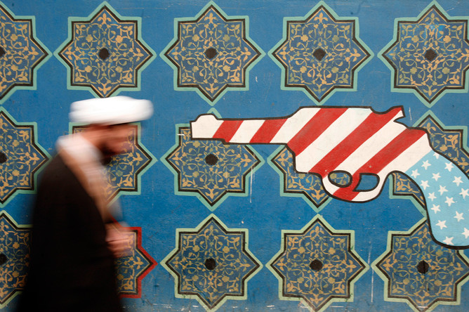 Иранец возле стены бывшего посольства США в Тегеране