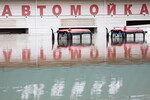 Крыши тракторов и подтопленное здание автомойки на улице Донгузская в Оренбурге, 14 апреля 2024 года