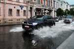 Автомобили едут по улице Петровка в Москве после дождя, 28 июня 2021 года