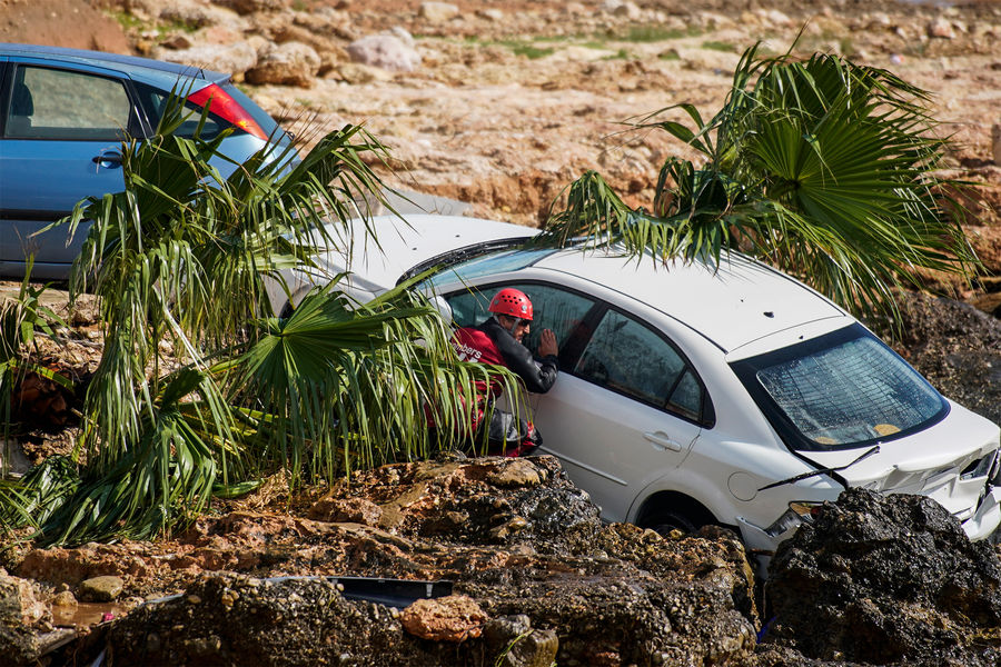 Спасатели проверяют разбитые автомобили, застрявшие на&nbsp;берегу моря в&nbsp;городе Альканар, Испания, 2 сентября 2021 года
