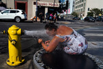 Жительница Лос-Анджелеса охлаждается водой из гидранта в жаркий день, 31 августа 2022 года