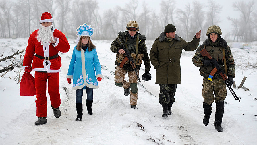 Местные жители в одежде Деда Мороза и Снегурочки во время посещения КПП украинской армии около Лисичанска в Луганской области, 2 января 2015 года