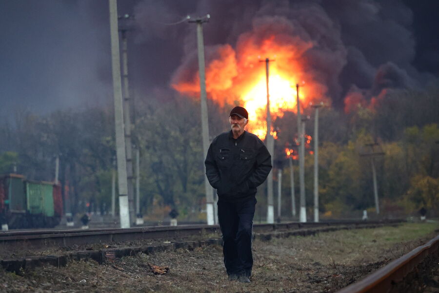 Местный житель на&nbsp;фоне пожара, возникшего в&nbsp;результате обстрела железнодорожной станции Шахтерска, 26&nbsp;октября 2022&nbsp;года