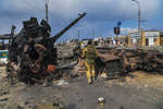 A fighter of the DPR People's Militia near a wrecked tank of the DPR army on Kuprin Street in Mariupol, March 2022