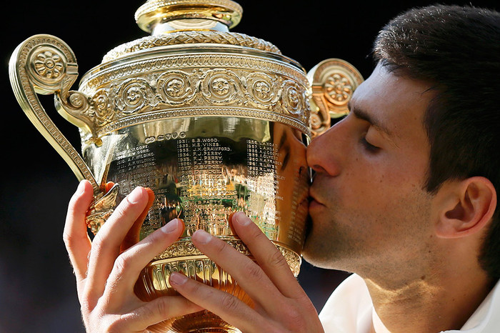 Новак Джокович целует кубок после победы над&nbsp;Роджером Федерером