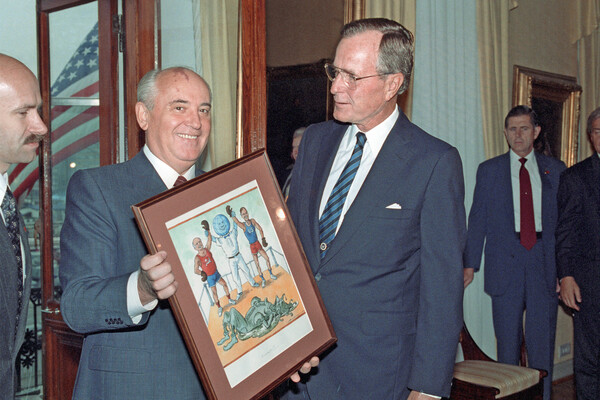 Президент СССР Михаил Горбачев вручает президенту США Джорджу Бушу (справа) дружеский шарж советского художника, Хельсинки, 1990&nbsp;год